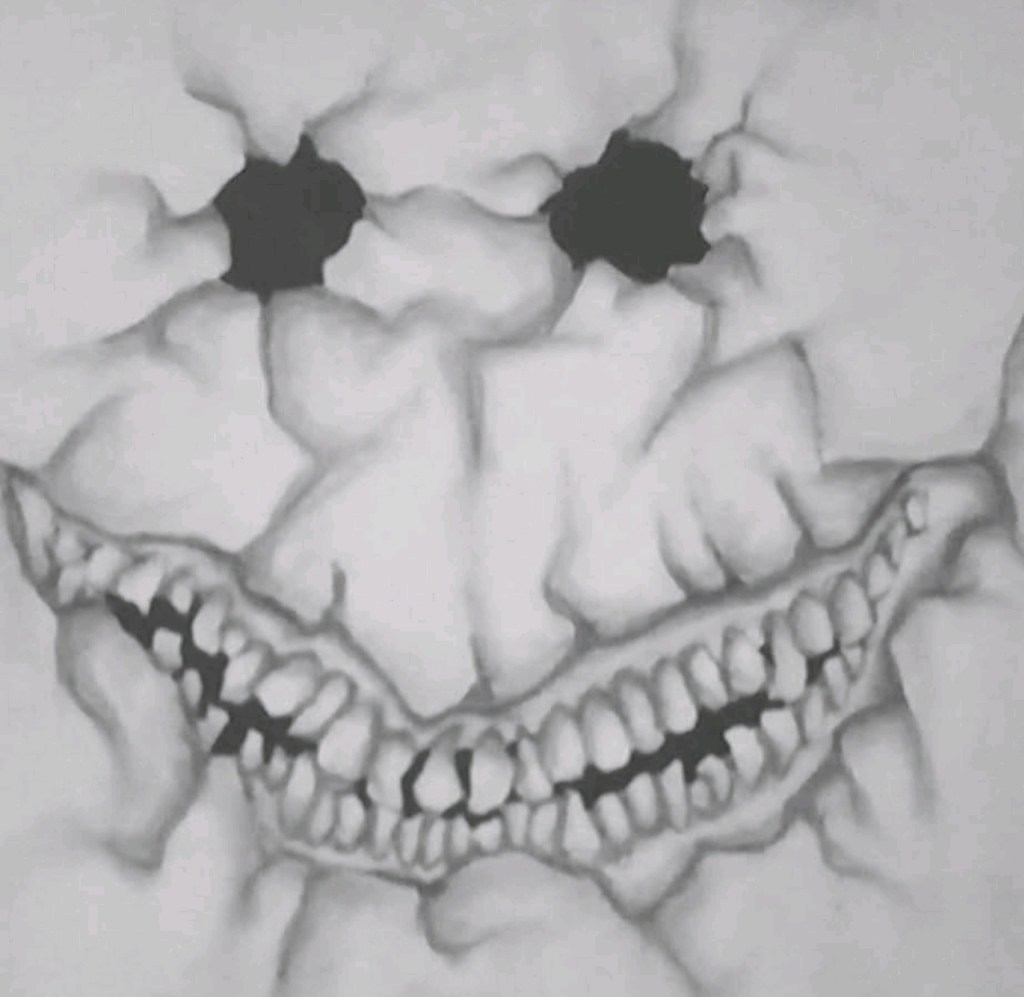 Monochrome drawing of a cracked face with dark eye sockets and a broad tooth-filled grin.